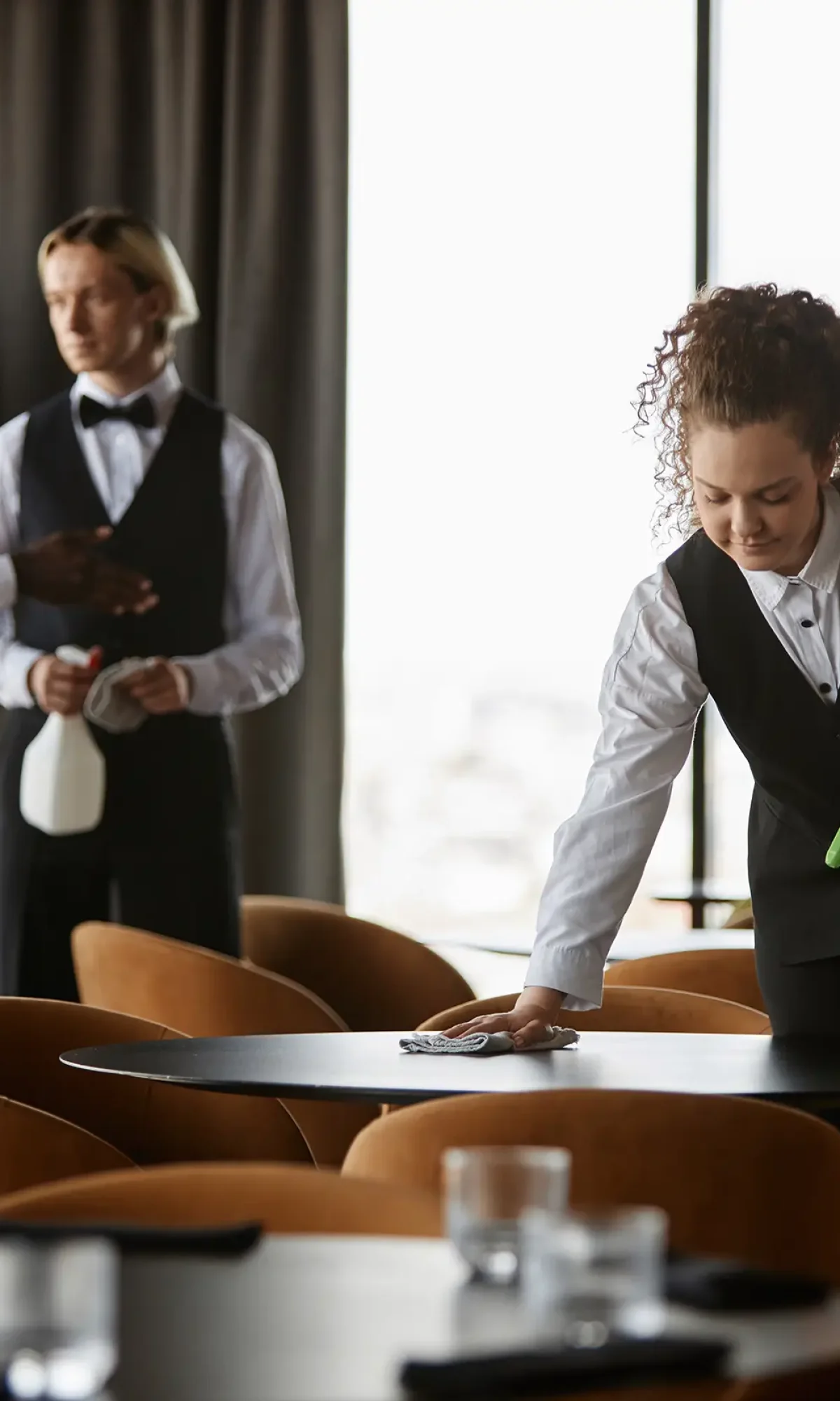 curly-haired-young-woman-as-waitress-wiping-dining-2026-01-08-07-40-45-utc copy
